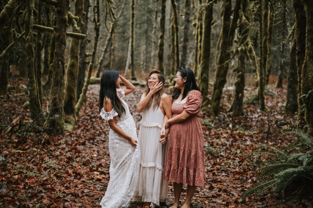 Two expecting friends laughing together in the misty forest