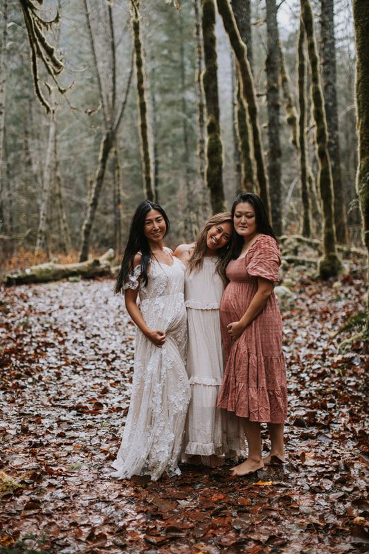 Maternity portrait of a mother-to-be cradling her belly near the cabin