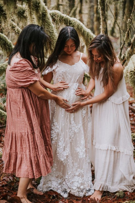 Close-up maternity portrait highlighting a baby bump outdoors