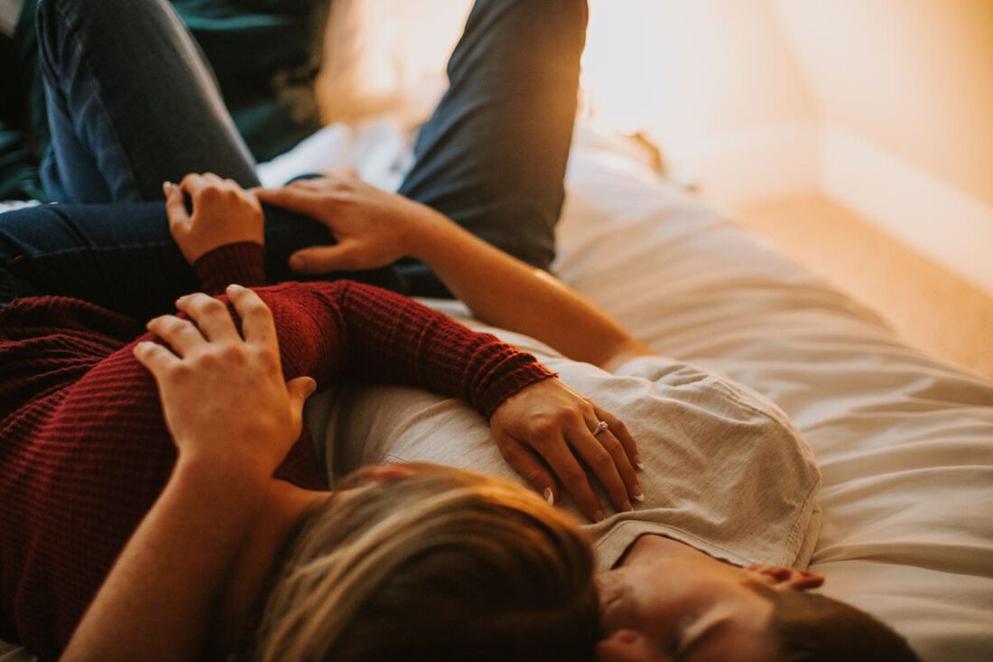 Engaged couple embracing on the porch of the A-frame cabin