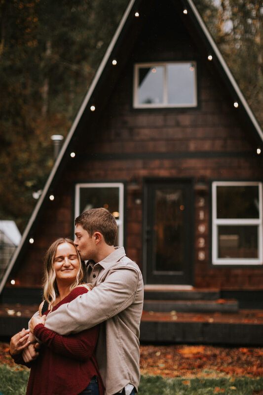Engagement portrait framed by the cabin's timber doorway
