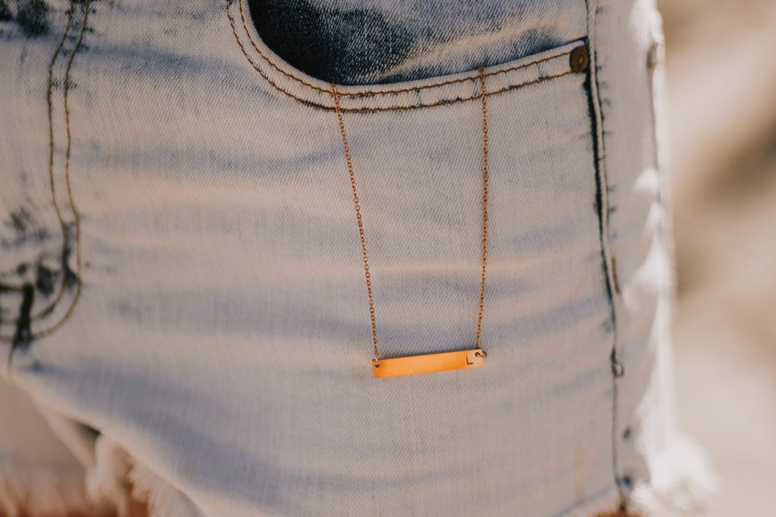 Lifestyle product photo of a hand stamped necklace from Maple Lane Jewelry