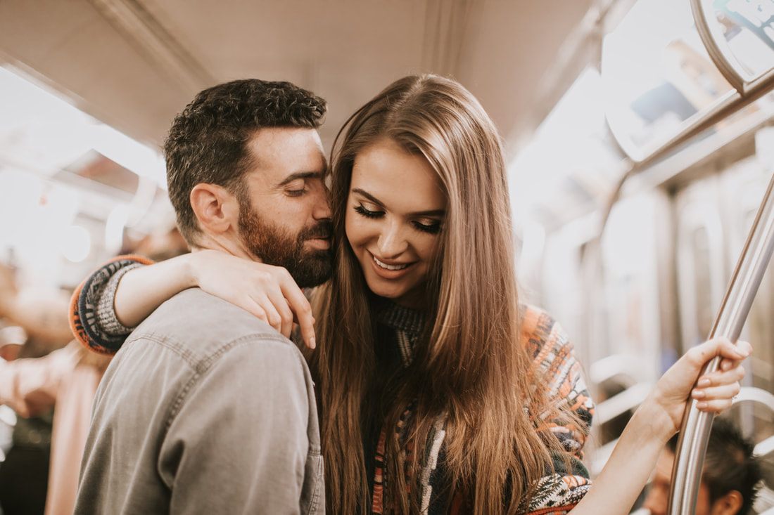 Engaged couple walking through a busy New York City crosswalk