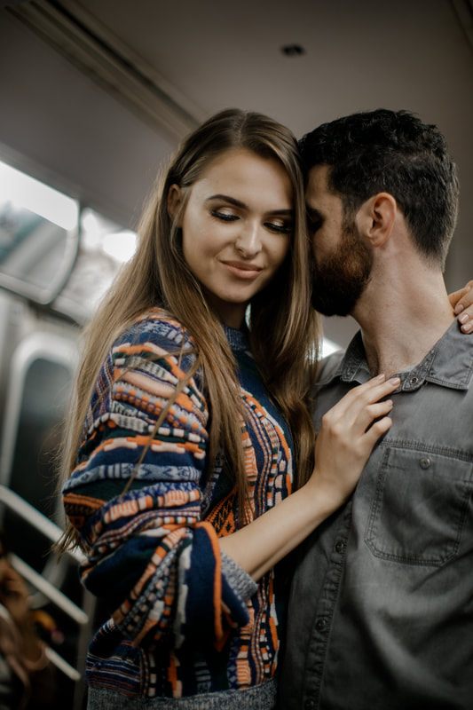 Engaged couple portrait with the New York City skyline behind them