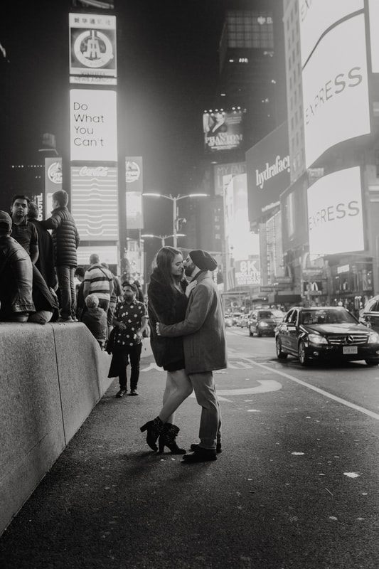 Engaged couple portrait with New York City traffic blurred behind them