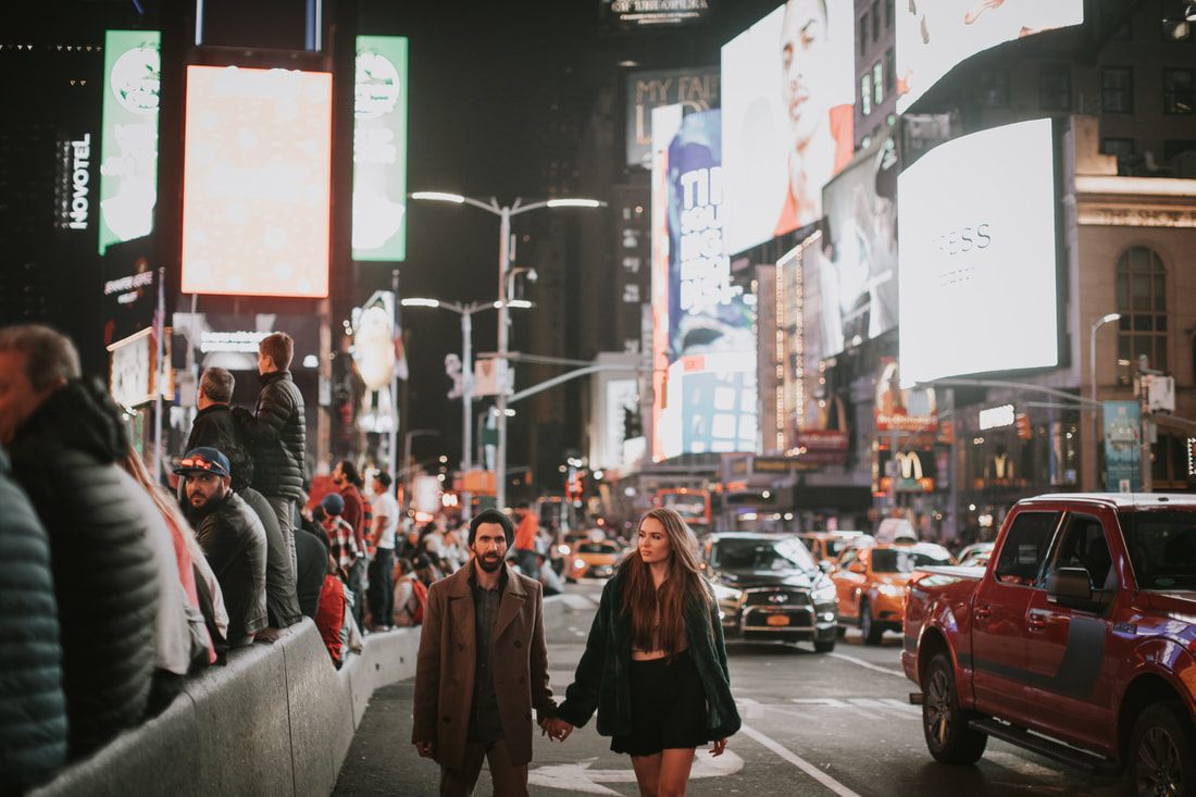 Couple sharing a close moment on a New York City corner at night