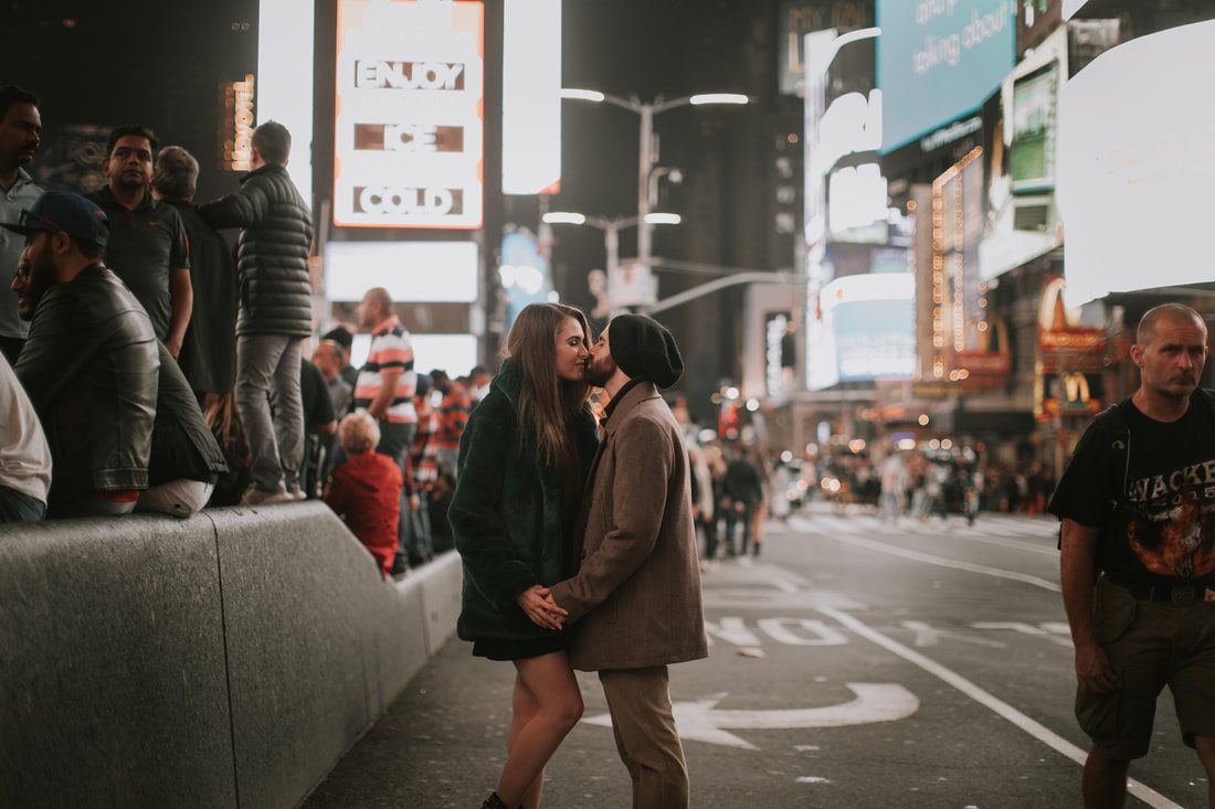 Couple walking hand in hand through New York City at night