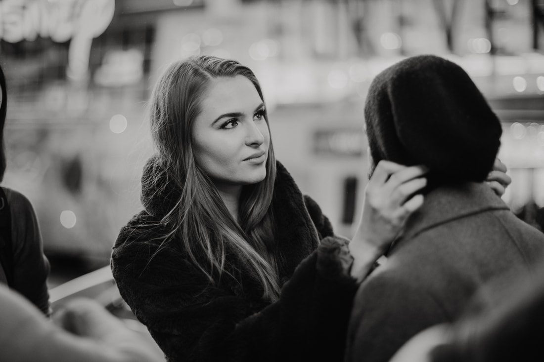 Couple standing close together inside a New York City subway car