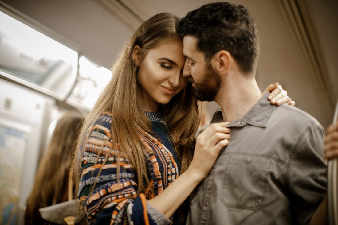 Engaged couple with Times Square billboards glowing behind them