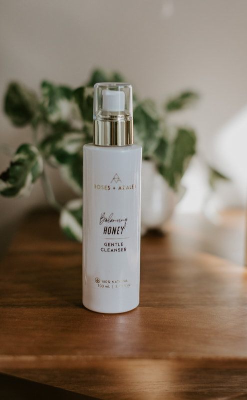 Botanical skincare bottle styled with fresh rose petals for a natural beauty brand shoot.