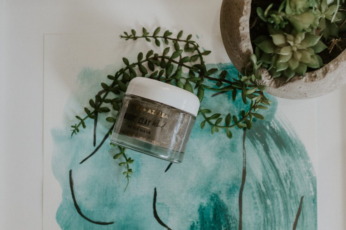 Styled flat-lay of Roses and Azalea skincare products with roses and azalea flowers.