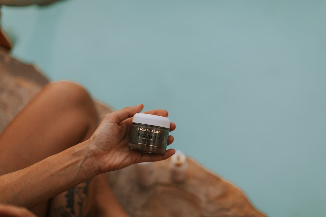 Overhead product photo of organic skincare packaging surrounded by botanical greenery.