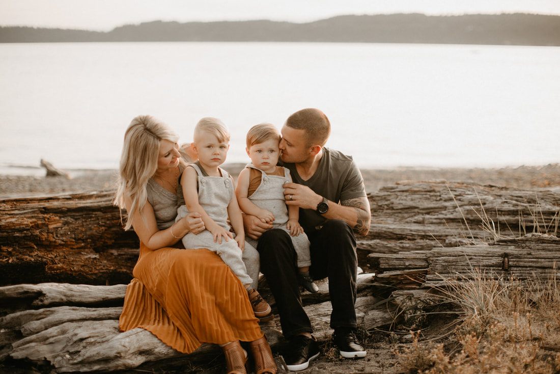 Mom and dad sharing a quiet moment with their sons on the beach