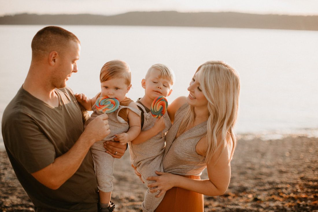 Family embracing on the sand during a Seattle beach photo session