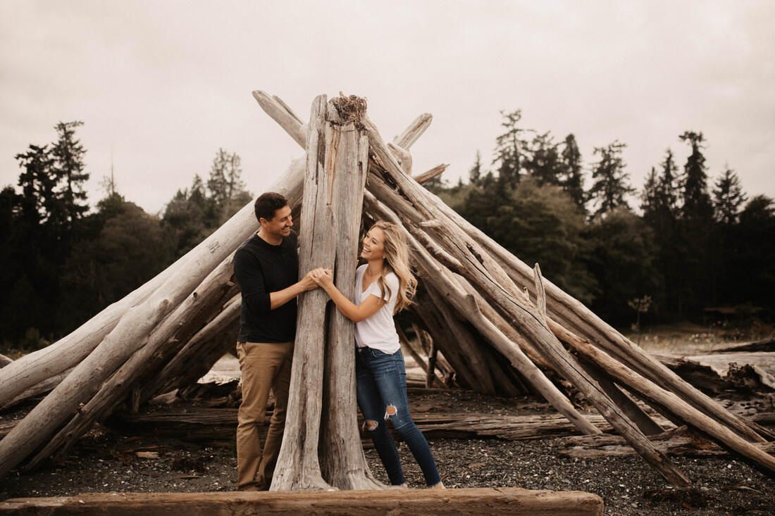 The couple laughing together further along the rocky shoreline