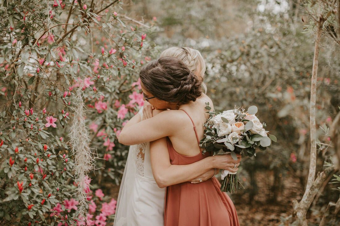 Wide shot of the couple walking along a moss-draped plantation path
