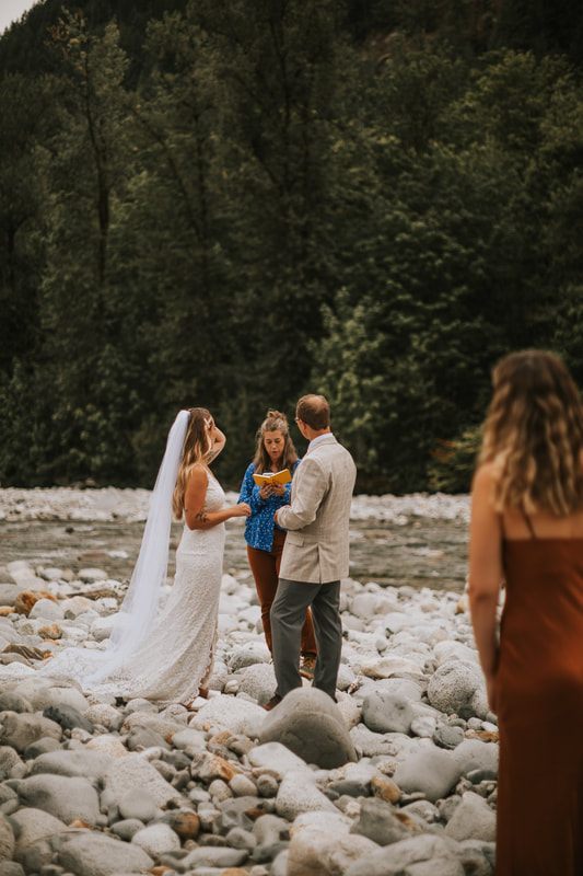 Bride twirling her dress with the river as a backdrop
