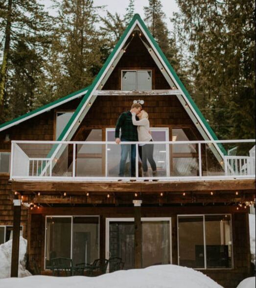 Couple standing together outside a PNW a-frame cabin