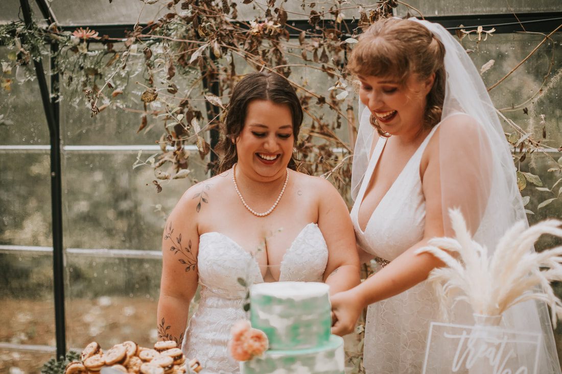 Two brides embracing on the porch of a Washington A-frame cabin, later in the celebration