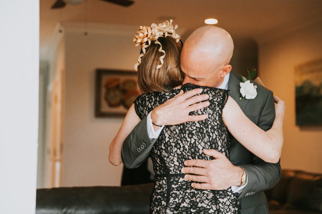Candid portrait of the couple embracing with the ocean behind them, as the celebration continued