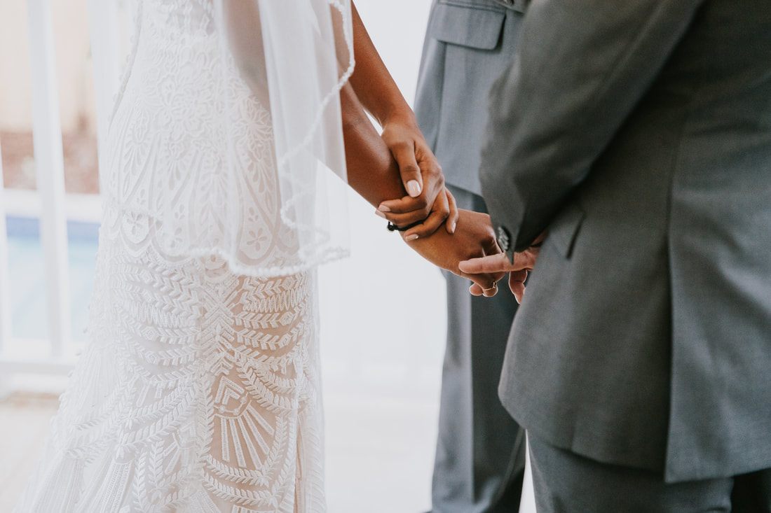 The couple exchanging vows during their intimate elopement ceremony on Isle of Palms, back at the beach house