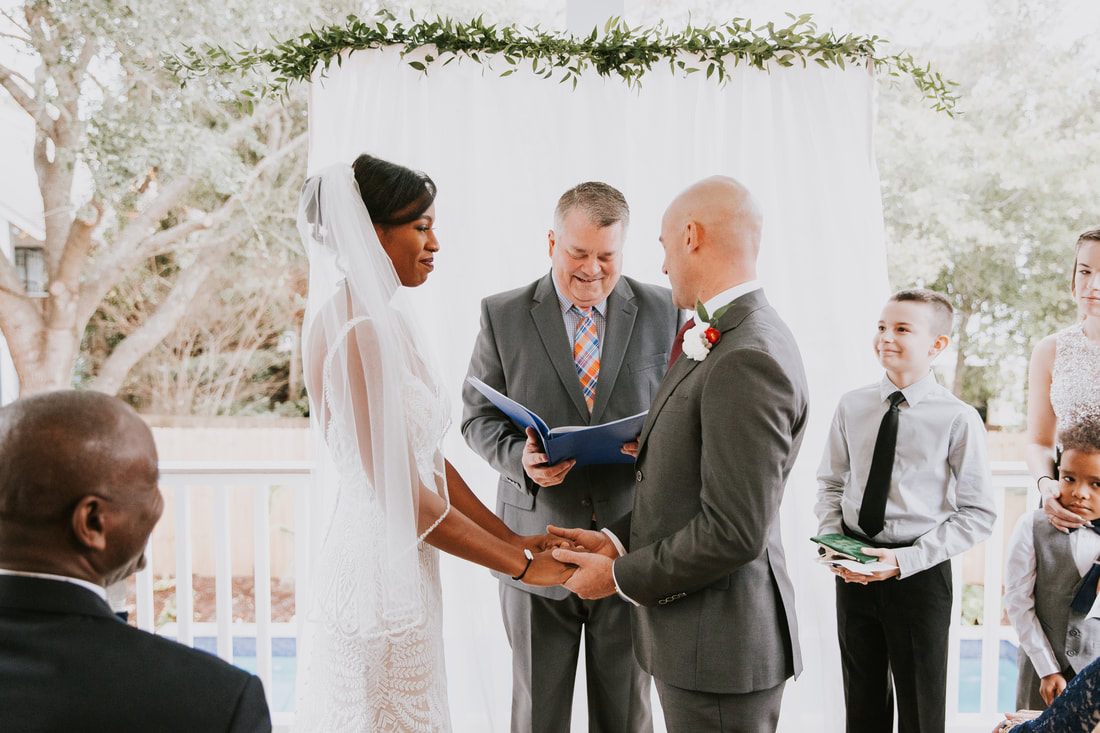 The bride and groom laughing together in the coastal breeze, back at the beach house