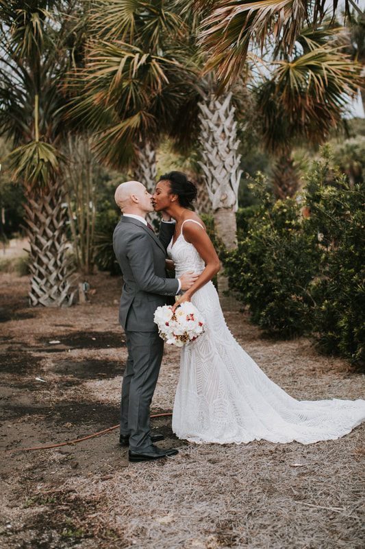Close-up of the couple holding hands during their first look on the beach, one more frame from the day