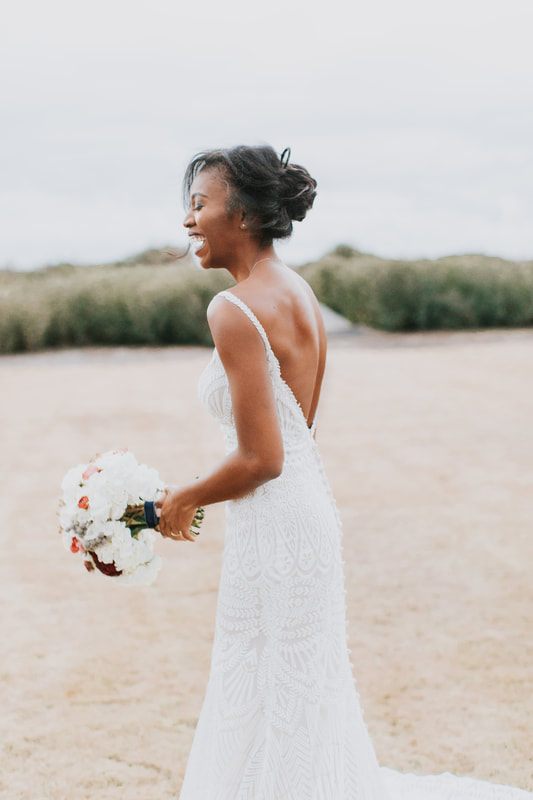 The bride and groom laughing together in the coastal breeze, one more frame from the day