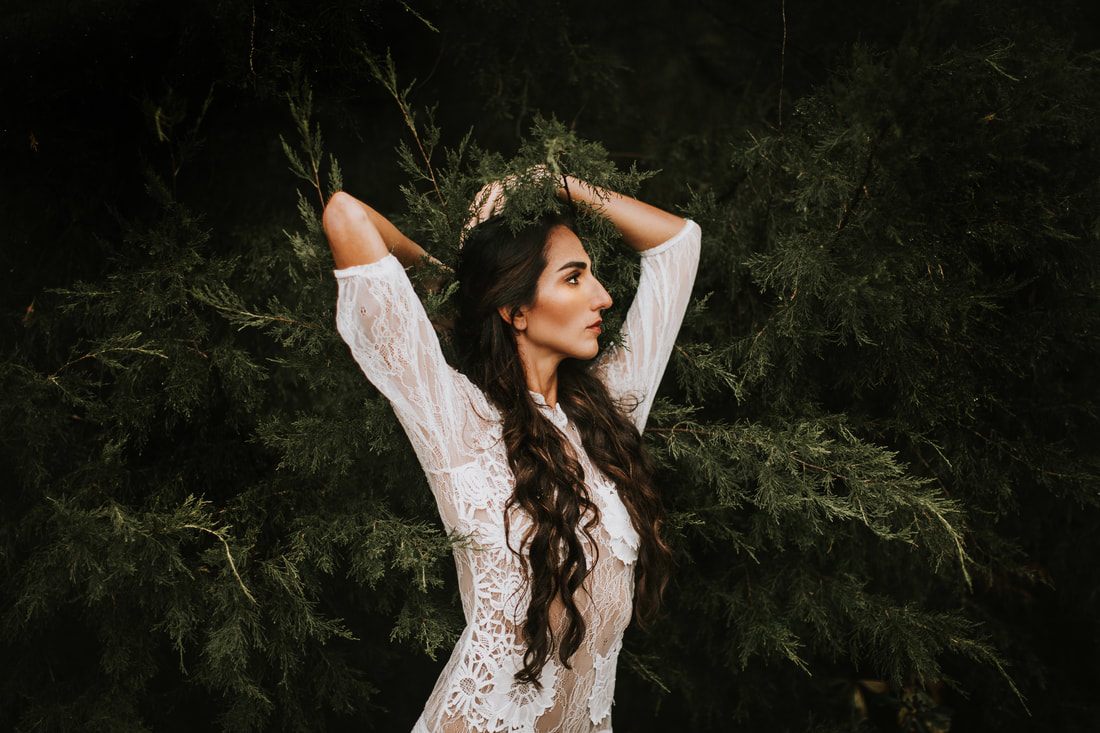 Bridal portrait of Anya in a flowing gown among forest trees