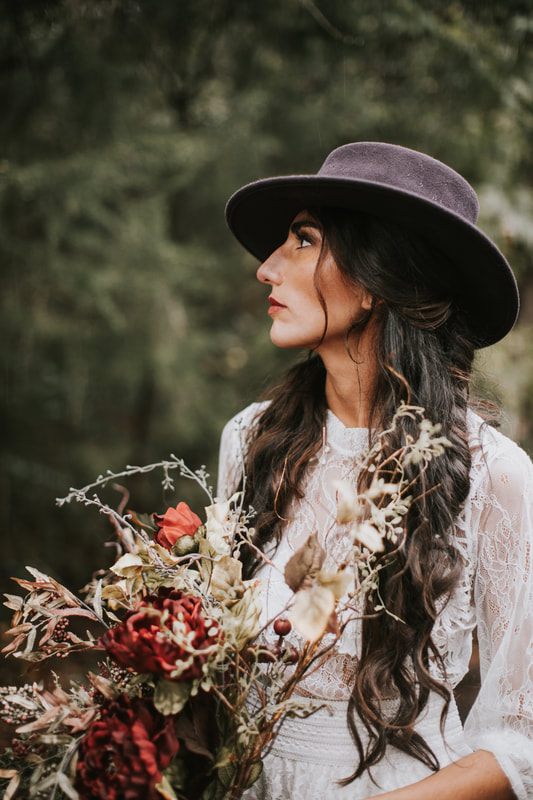 Bridal gown detail captured against green forest foliage