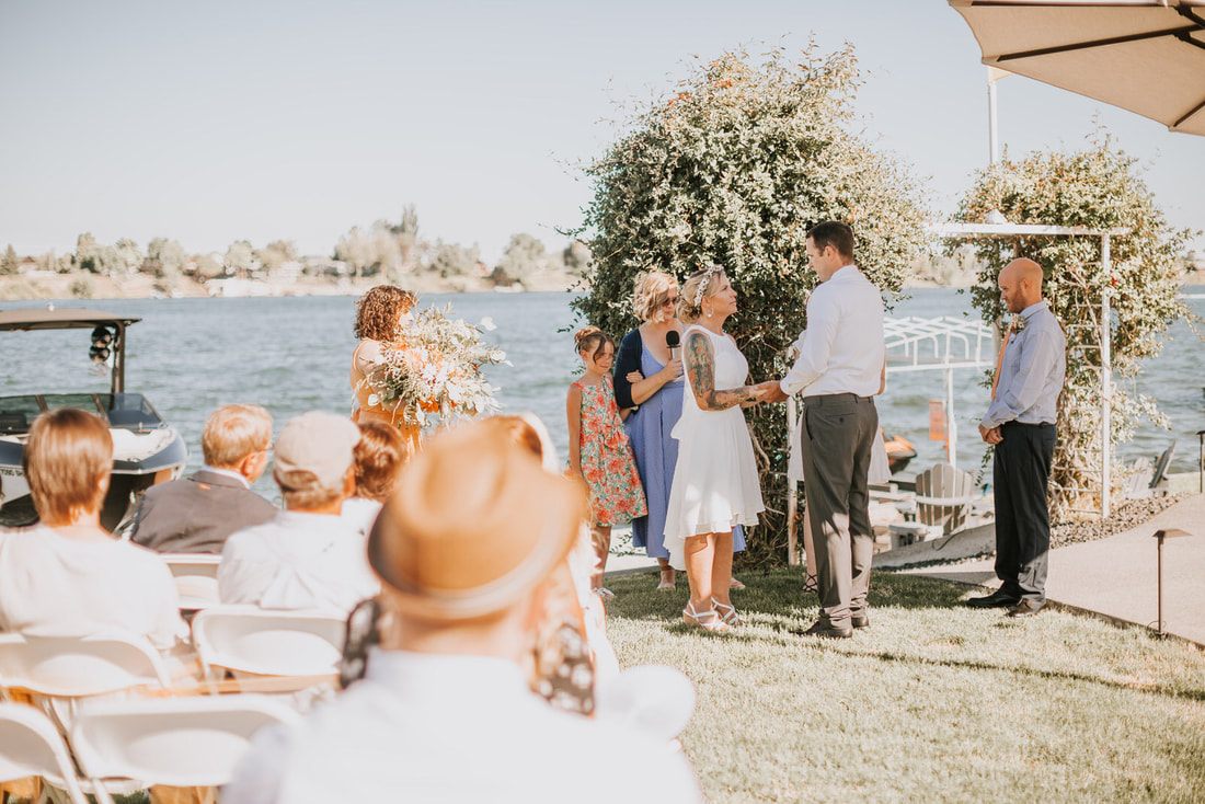 Guests laughing together during the intimate backyard reception at Moses Lake.