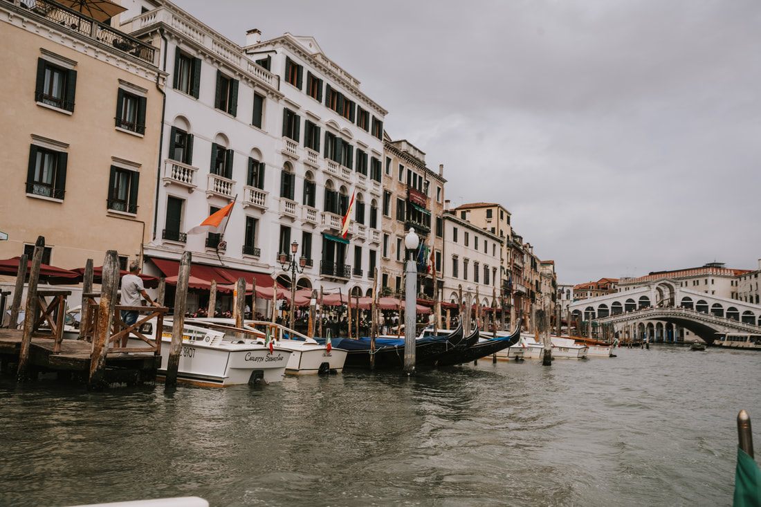 Locals and tourists along a Venice canal walkway