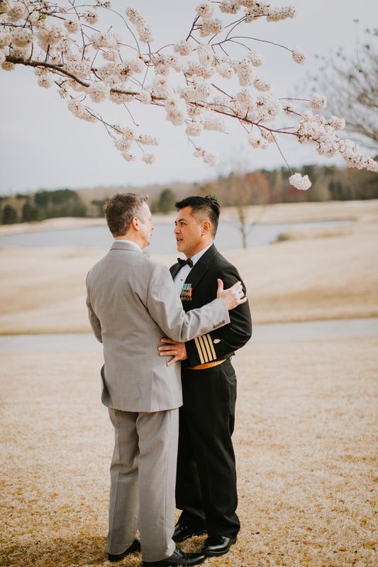 Fritz and Christopher stand together, all smiles, on their wedding day.