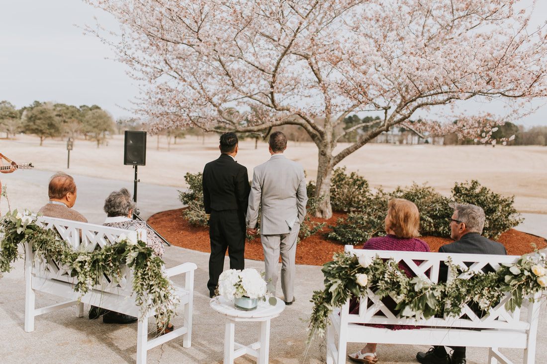 Fritz and Christopher walk hand in hand along the beach in Virginia Beach.
