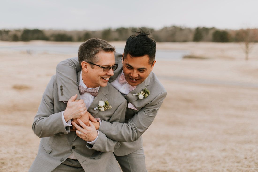 Fritz and Christopher stand together, all smiles, on their wedding day.