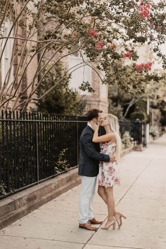 The couple embracing on the sidewalk near the Charleston waterfront