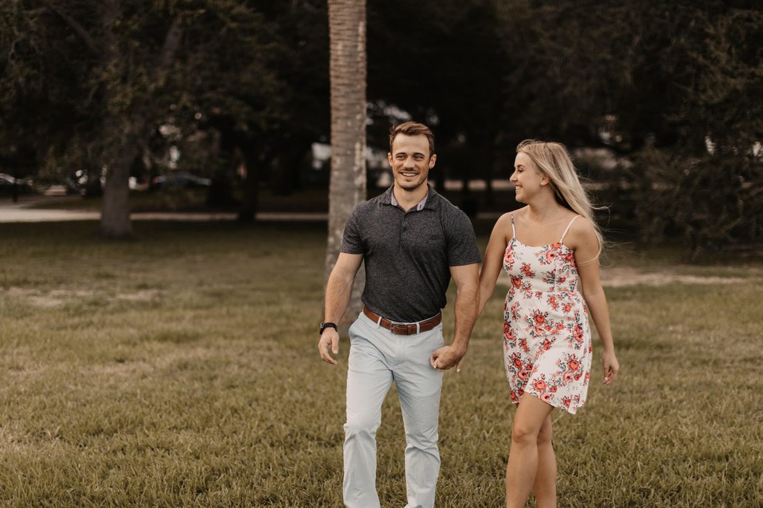 Alex and Jessica laughing together beside a historic Charleston church