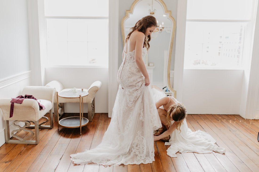 Bride getting her makeup touched up near a window at Gadsden House