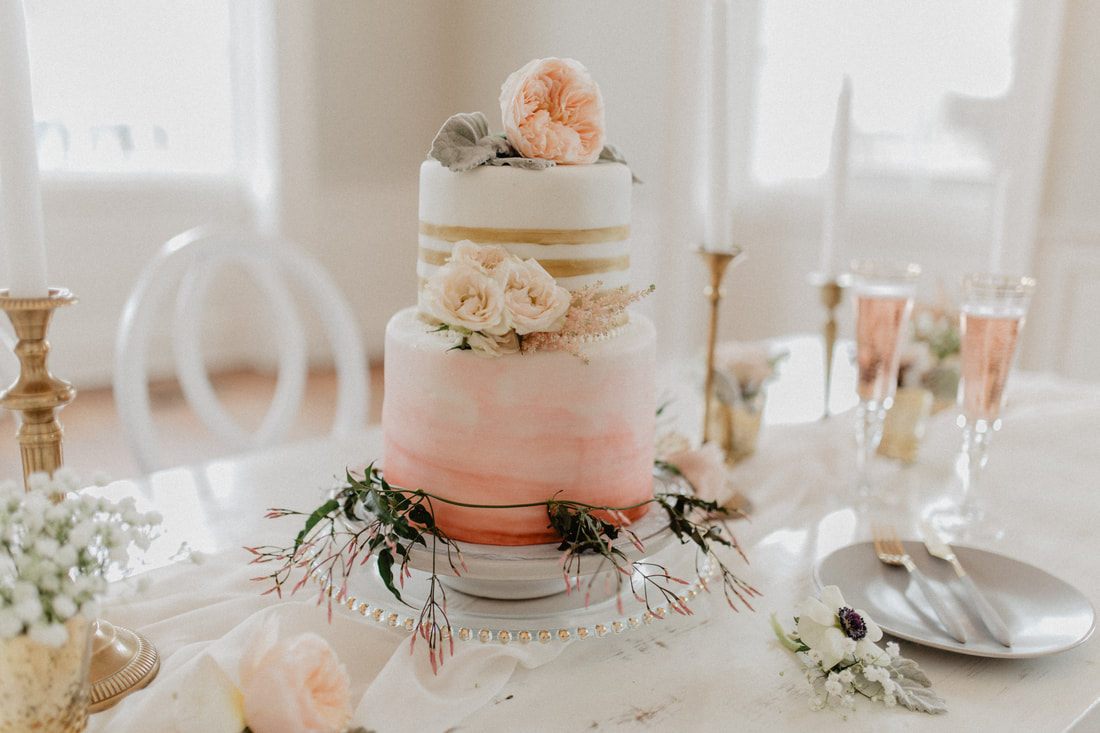 Detail of a wedding gown's train pooling on the hardwood floor