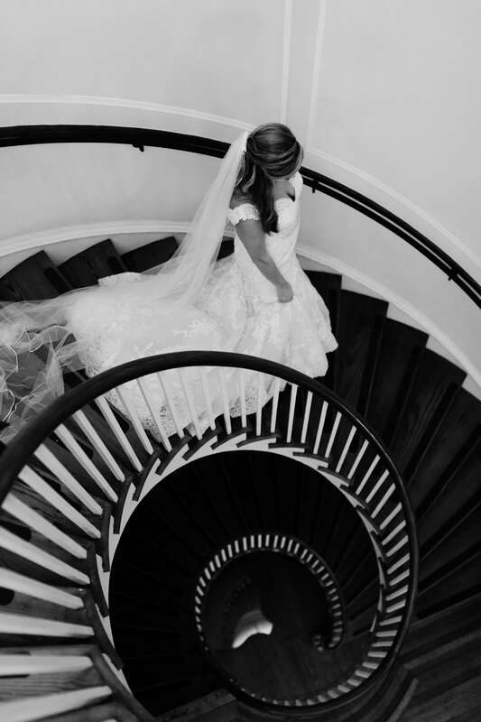 Lauren seated on the plantation's grand staircase in her wedding dress