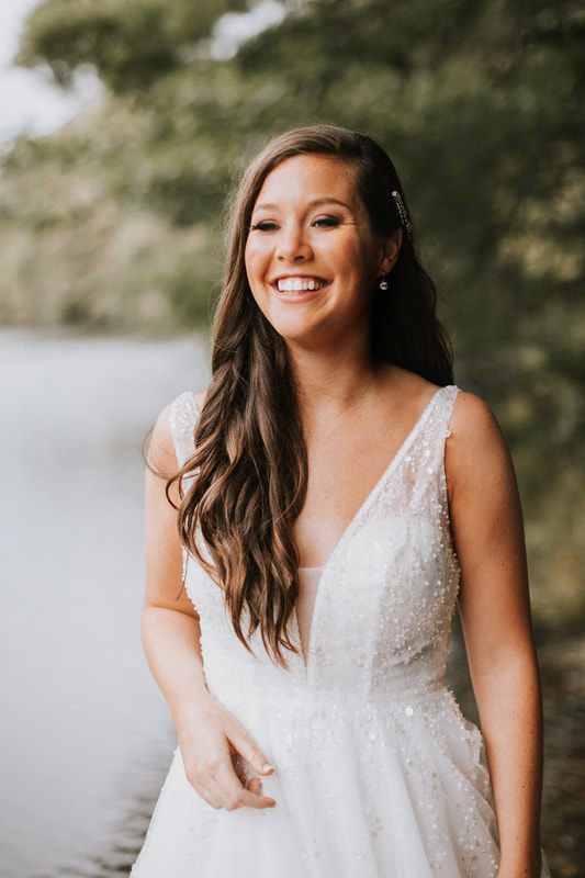Cassandra and Charlie laugh together during a candid moment at their wedding.