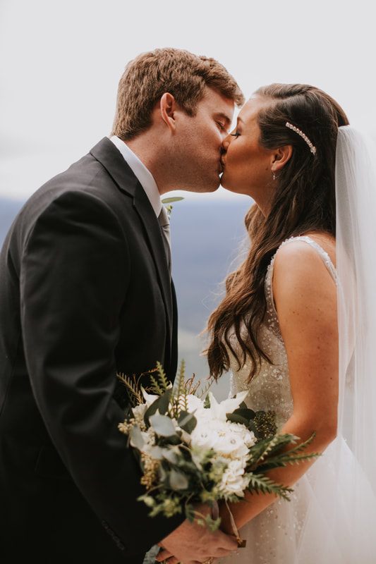 Cassandra and Charlie laugh together during a candid moment at their wedding.