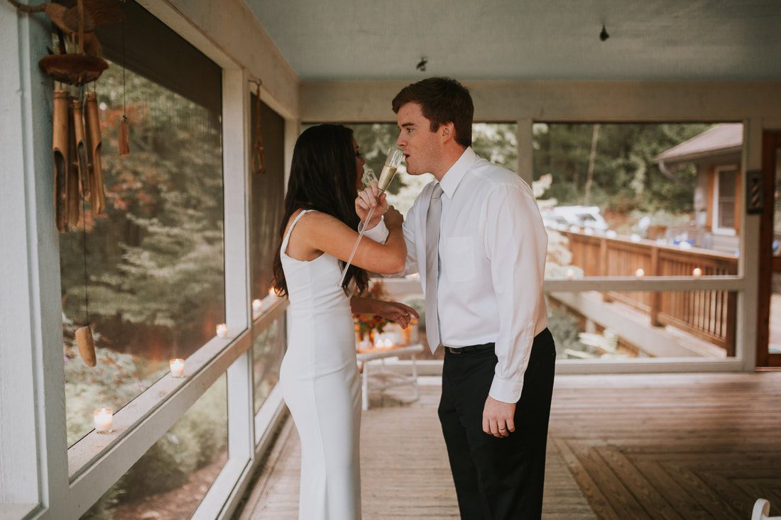 Cassandra and Charlie walk hand in hand with sweeping mountain views behind them.