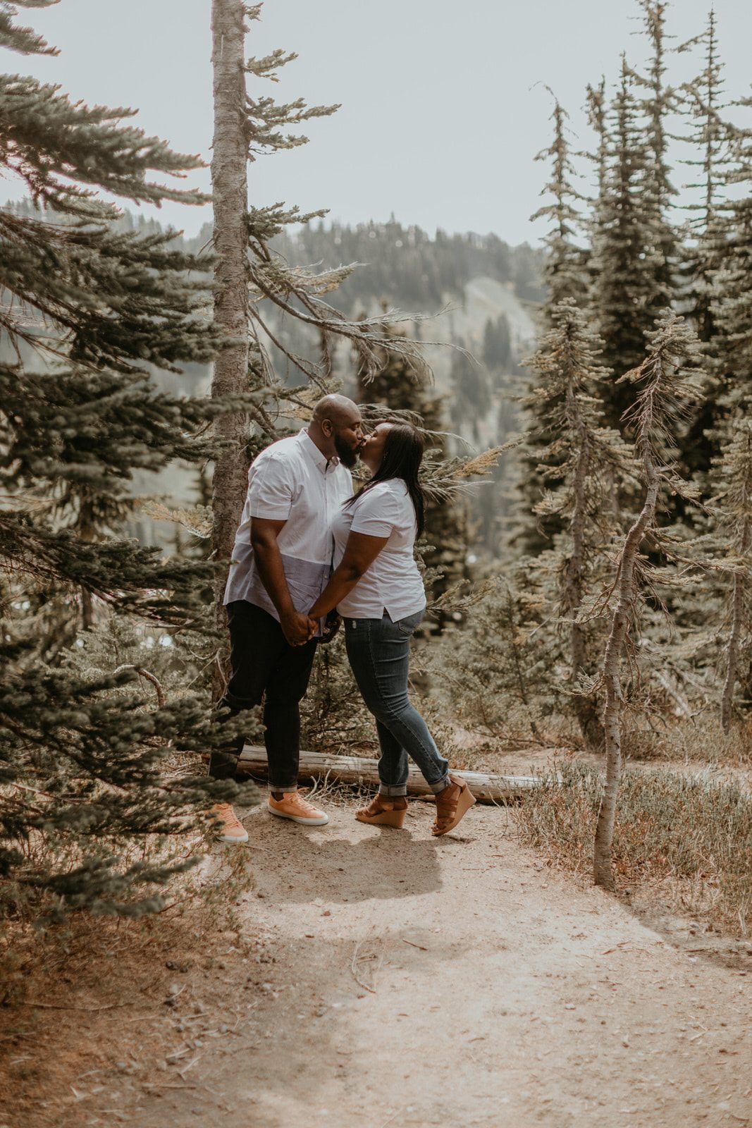 Tyeisha and Adam holding hands with dramatic mountain scenery behind them