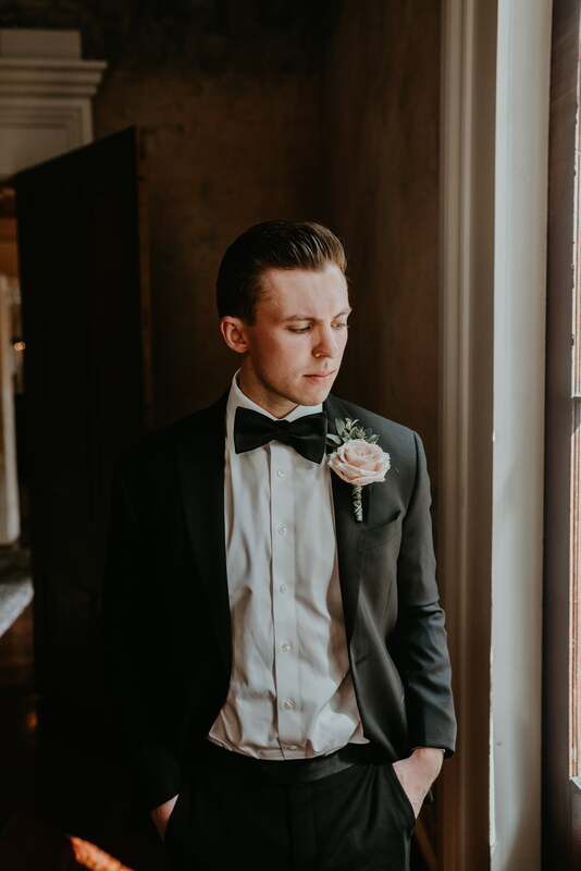 Groom buttoning his jacket in quiet anticipation before the ceremony