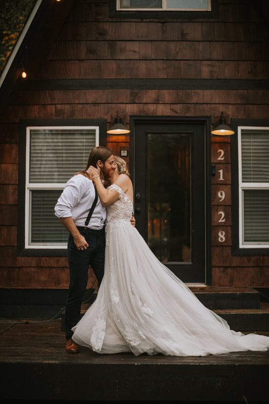Bride and groom embracing beneath the fog-laced trees during their ceremony.