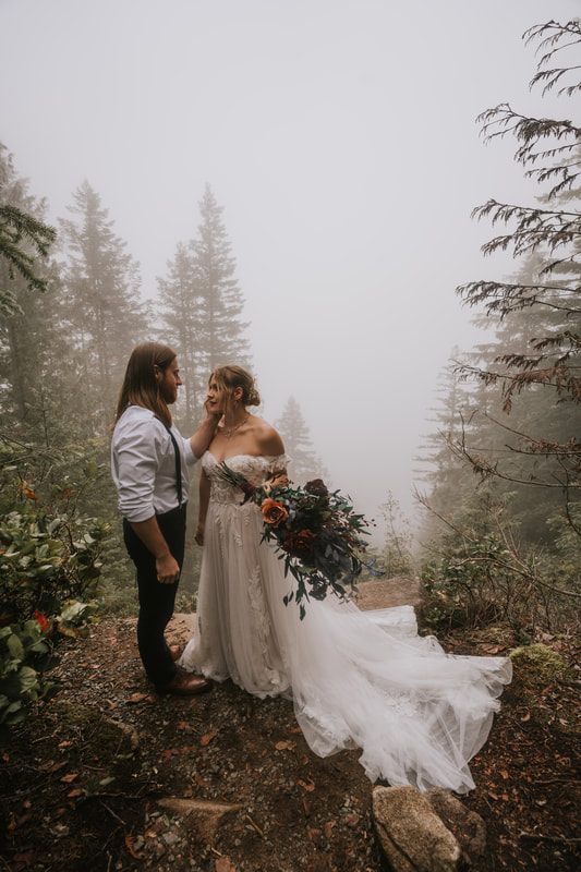 Tiana and Malik sharing a quiet moment in the foggy PNW forest.