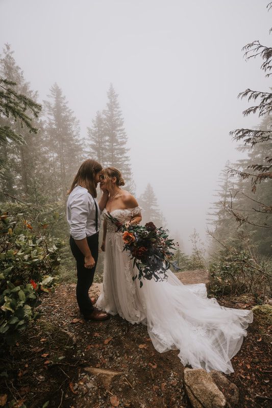 Bride and groom walking together on the fog-covered Heybrook Lookout Trail.