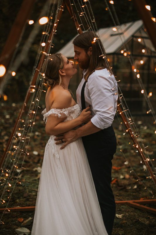 Bride and groom embracing beneath the fog-laced trees during their ceremony.