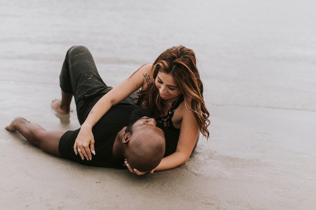 Nicole and Deno Mickle with their daughters silhouetted against the ocean